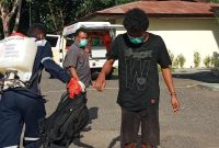 Stephen disemprot antiseptik sebelum masuk ke lokasi karantina terpusat, Senin (27/4)