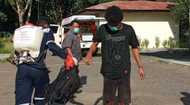 Stephen disemprot antiseptik sebelum masuk ke lokasi karantina terpusat, Senin (27/4)