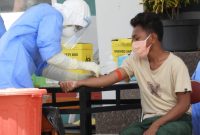 Petugas kesehatan sedang mengambil sampel darah seorang warga karantina di Gedung SCC, Sabtu (11/4)