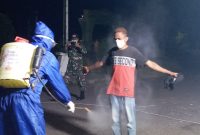 Seorang pelaku perjalanan disemprot cairan antiseptik, Minggu (10/5) malam