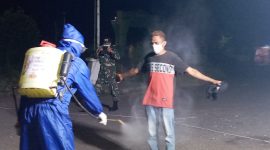 Seorang pelaku perjalanan disemprot cairan antiseptik, Minggu (10/5) malam