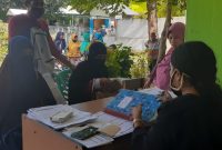 Penerima manfaat sembako murni di Desa Parumaan sedang membuka rekening, Sabtu (2/5)
