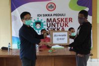 Dokter Frisky Ronald Tua menyerahkan masker kain di Kecamatan Magepanda pekan lalu