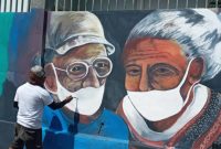 Seniman mural sedang melukis pada sebuah tembok di Kelurahan Kota Uneng, Jumat (15/5)
