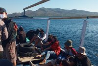 Warga masyarakat menumpang kapal motor menuju lokasi pengibaran bendera merah putih, Sabtu (15/8)