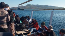 Warga masyarakat menumpang kapal motor menuju lokasi pengibaran bendera merah putih, Sabtu (15/8)