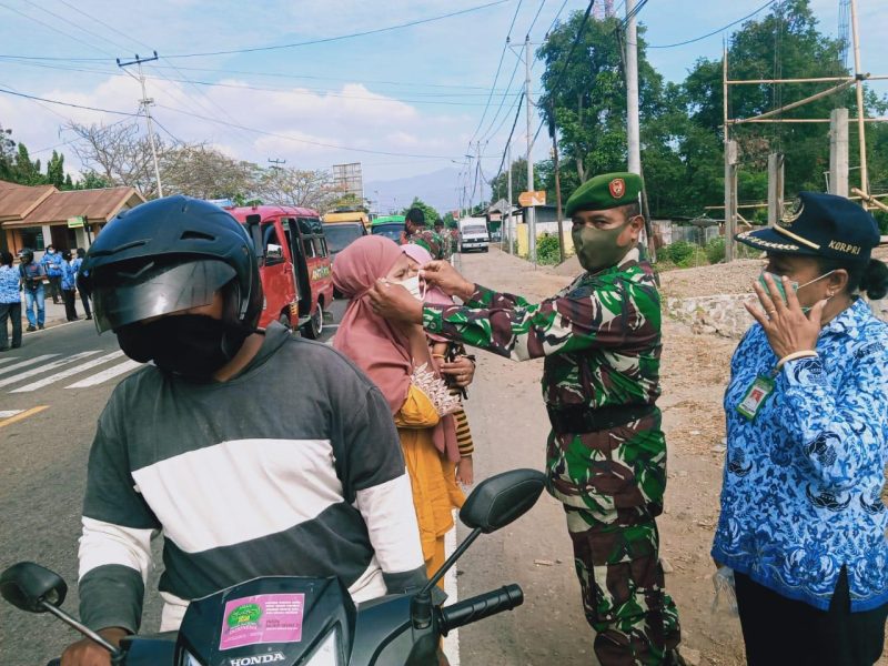 Danramil Kewapante memasang masker kepada warga yang terjaring tidak mengenakan masker, Kamis (17/9) (foto: istimewa)