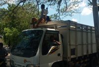 Truk pelintas jalan berhati-hati melewati jalan yang terhalang kabel, Senin (26/10)