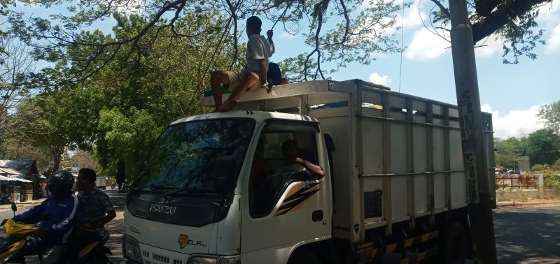 Truk pelintas jalan berhati-hati melewati jalan yang terhalang kabel, Senin (26/10)