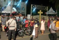 Umat mengikuti Misa Malam Natal dari depan pintu masuk gerbang utama Gereja Katedral, Kamis (24/12) malam