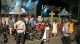 Umat mengikuti Misa Malam Natal dari depan pintu masuk gerbang utama Gereja Katedral, Kamis (24/12) malam