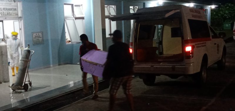 Ambulance menurunkan peti jenazah di ruang isolasi RSUD TC Hillers Maumere, Senin (28/12) malam