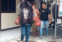 Terduka pelaku Y menutup wajahnya saat digelandang Tim Buser Flotim ke mobil untuk diangkut ke Mapolres Flotim, Minggu (24/1)