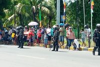 Warga Kota Maumere menunggu kedatangan Presiden Jokowi di depan Hotel Permata Sari, Selasa (23/2)