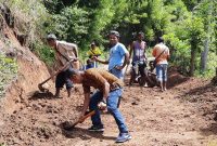 Kepala Desa Tuwa (baju coklat) memimpin warga Paipenga membersihkan material longsoran, Selasa (16/2) (foto: istimewa)