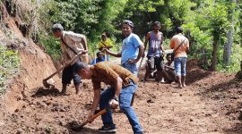 Kepala Desa Tuwa (baju coklat) memimpin warga Paipenga membersihkan material longsoran, Selasa (16/2) (foto: istimewa)