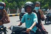 Seorang tukang ojek tidak mengenakan masker melintas di Jalan Ahmad Yani, Senin (8/3)