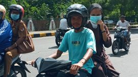 Seorang tukang ojek tidak mengenakan masker melintas di Jalan Ahmad Yani, Senin (8/3)