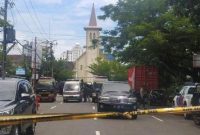 Polisi membentang garis polisi di depan Gereja Katedral Makasar, Minggu (28/3) (foto: istimewa)