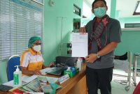 Kepala BPJS Kesehatan Cabang Maumere I Gusti Ngurah Arie Mayanugraha menunjukkan sertifikat telah melaksakan vaksinasi
