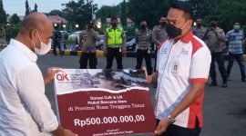 Kepala OJK Robert Sianipar menyerahkan donasi Rp 500 juta secara simbolis, Jumat (9/4)