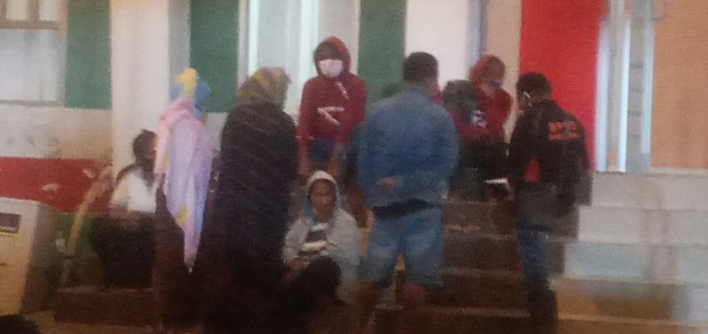 Warga Nualolo yang baru terpapar sedang istirahat di depan Gedung SCC, Selasa (20/4)