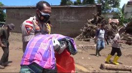 Wakapolres Flotim Kompol Yance Seran membopong jasad bayi yang meninggal, Rabu (7/4) siang (foto: istimewa)