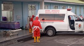 Petugas pemakaman sedang bersiap-siap mengevakuasi jenazah ke TPK Covid, Selasa (6/7)