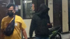 Seorang penyidik mengawal pemuda yang menantang keganasan Covid, Jumat (23/7) malam