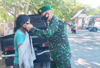 Dandim Sikka memakaikan masker kepada Anastasia, salah seorang pengunjung Pasar Alok, Selasa (24/8)