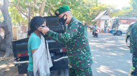 Dandim Sikka memakaikan masker kepada Anastasia, salah seorang pengunjung Pasar Alok, Selasa (24/8)