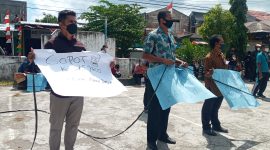 Seorang peserta aksi memegang poster yang mendesak pencopotan Kadis PKO Sikka, Jumat (3/9)
