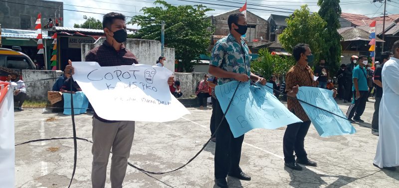 Seorang peserta aksi memegang poster yang mendesak pencopotan Kadis PKO Sikka, Jumat (3/9)
