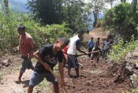 Warga sedang gotong-royong membersihkan ruas jalan dari material longsor, Jumat (17/9) (foto: istimewa)