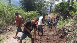 Warga sedang gotong-royong membersihkan ruas jalan dari material longsor, Jumat (17/9) (foto: istimewa)