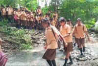 Ratusan pelajar SMPN 1 Paga menyeberangi sungai akibat jebolnya jembatan, Jumat (21/1)