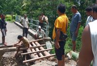 Warga perbaiki jembatan yang jebol di Dusun Kangarusa Dwsa Wolowiro, Jumat (21/1)
