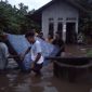 Warga membantu evakuasi korban yang rumahnya terendam banjir di Wairbor Kelurahan Wailiti, Kamis (24/2)