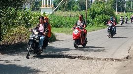 Kendaraan roda dua terpaksa melintas pada sisi kanan untuk menghindar jalan berlubang besar di Maumere, Selasa (1/3)
