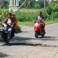Kendaraan roda dua terpaksa melintas pada sisi kanan untuk menghindar jalan berlubang besar di Maumere, Selasa (1/3)