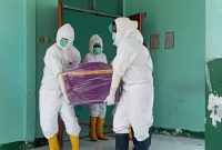 Jenazah SA dibawa petugas Covid-19 untuk dimakamkan di Desa Nangatobong, Sabtu (12/3)