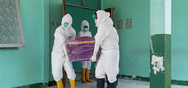 Jenazah SA dibawa petugas Covid-19 untuk dimakamkan di Desa Nangatobong, Sabtu (12/3)