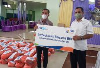 Manajer Bisnis Kecil BRI Cabang Maumere Edy M Subhan (kiri) menyerahkan secara simbolis bantuan 100 paket sembako BRI Peduli kepada Pendeta GMIT Ferluminggus Bako, Selasa (5/4) 