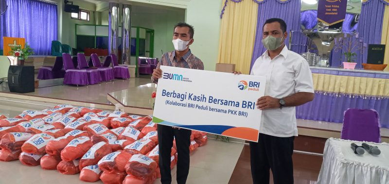 Manajer Bisnis Kecil BRI Cabang Maumere Edy M Subhan (kiri) menyerahkan secara simbolis bantuan 100 paket sembako BRI Peduli kepada Pendeta GMIT Ferluminggus Bako, Selasa (5/4) 