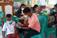 Seorang pelajar Kelas I SDI Kota Uneng mengikuti vaksinasi kedua, Kamis (7/4)