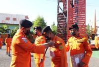 Kepala Kantor Pencarian dan Pertolongan Maumere Lalu Wahyu Efendi mengalungkan ID Card kepada rescuer peserta kegiatan latihan beregu dan satuan di perairan, Senin (22/8) (foto: istimewa)