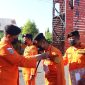 Kepala Kantor Pencarian dan Pertolongan Maumere Lalu Wahyu Efendi mengalungkan ID Card kepada rescuer peserta kegiatan latihan beregu dan satuan di perairan, Senin (22/8) (foto: istimewa)
