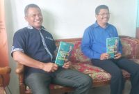 Agustinus Romualdus Heni selaku Ketua Panitia Peluncuran Buku dan Manajer Puskopdit Swadaya Utama Maumere Fransiscus De Fransu memperlihatkan buku Dian Yang Tetap Bercahaya di Kantor Puskopdit Swadaya Utama, Senin (4/10)