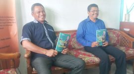 Agustinus Romualdus Heni selaku Ketua Panitia Peluncuran Buku dan Manajer Puskopdit Swadaya Utama Maumere Fransiscus De Fransu memperlihatkan buku Dian Yang Tetap Bercahaya di Kantor Puskopdit Swadaya Utama, Senin (4/10)