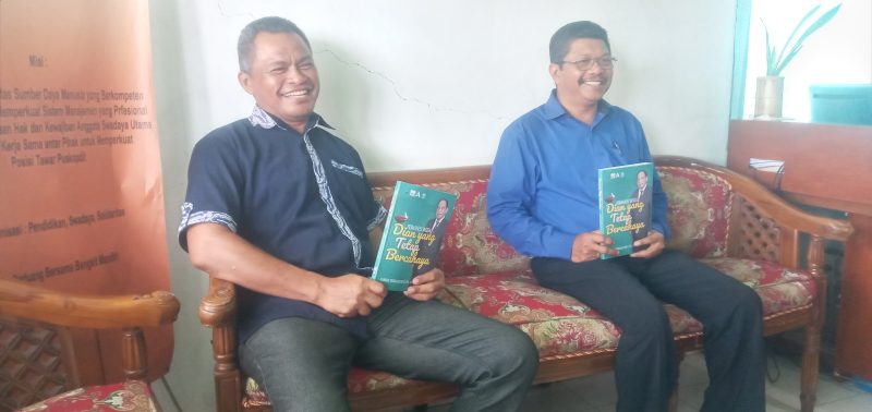 Agustinus Romualdus Heni selaku Ketua Panitia Peluncuran Buku dan Manajer Puskopdit Swadaya Utama Maumere Fransiscus De Fransu memperlihatkan buku Dian Yang Tetap Bercahaya di Kantor Puskopdit Swadaya Utama, Senin (4/10)